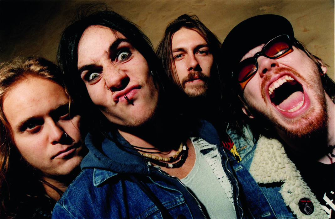 Die vier Bandmitglieder von The Hellacopters posieren für eine Promofoto, Nicke Andersson reißt den Mund auf.